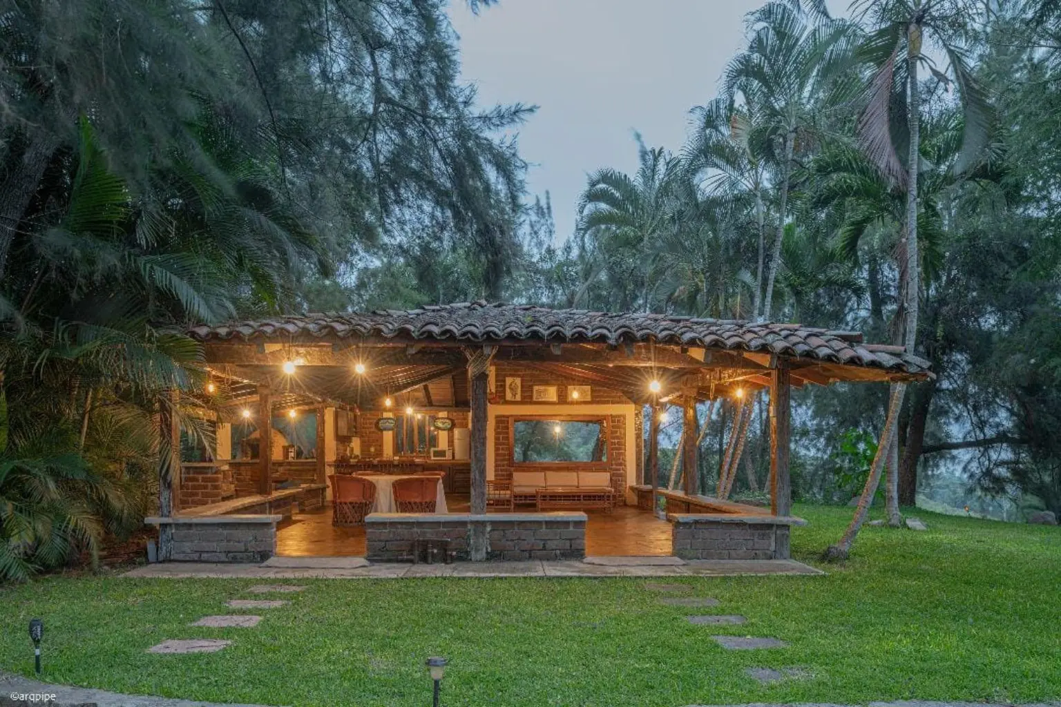 Vista frontal de la terraza de Rancho Fuencaudal iluminada al atardecer
